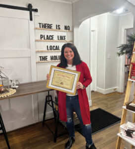 Shannon Gallo of the Oyster Candle Company & Coastal Gifts holds a Best of Mount Pleasant plaque awarded to her shop as Best Place to Buy a Gift.